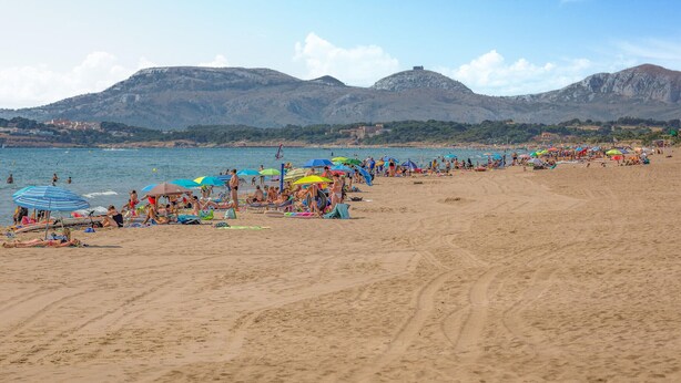A beach with people sunbathing and swimming, umbrellas, and a mountainous backdrop. - Cozy home in Sant Miquel de Fluvià (Sant Miquel de Fluvià)