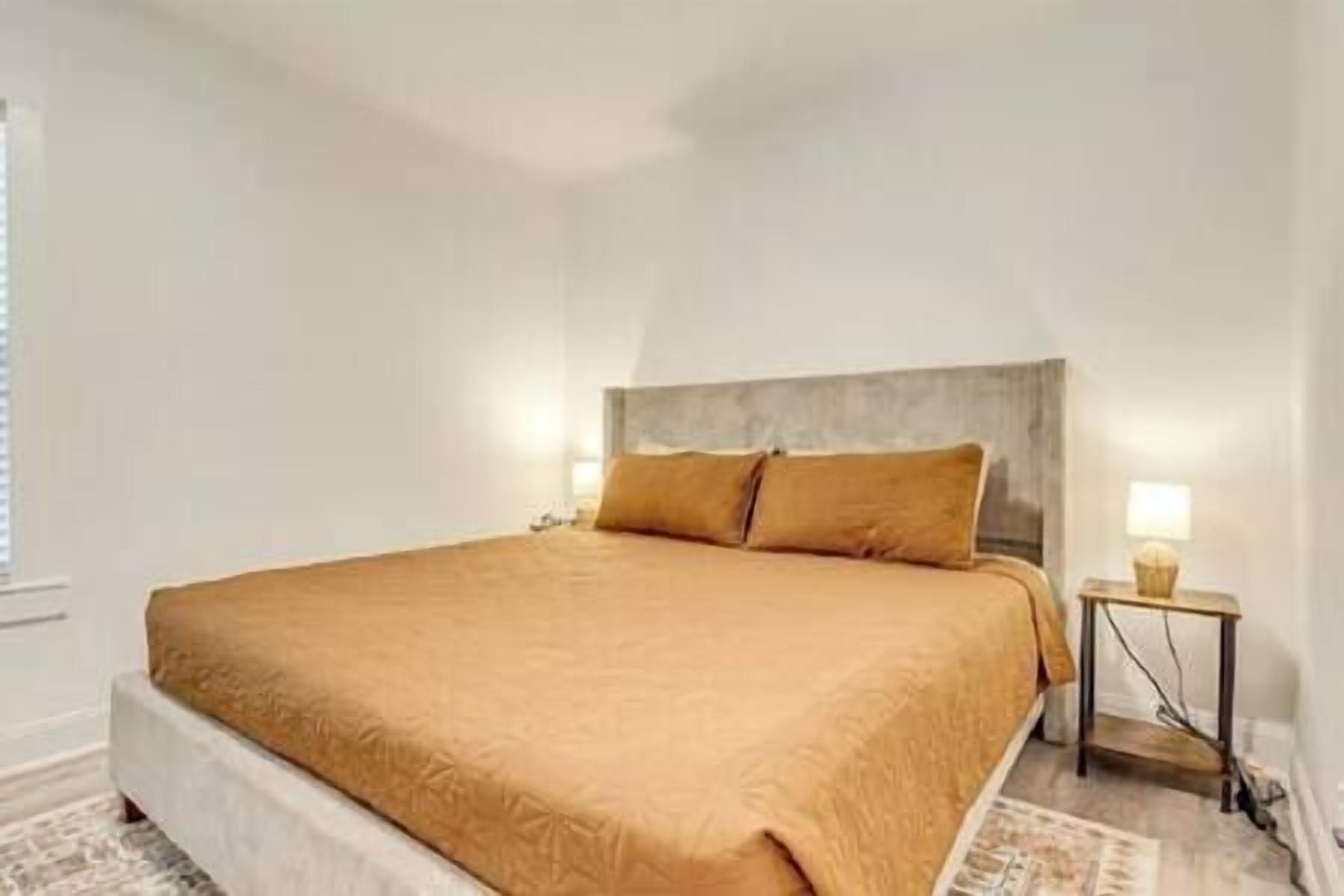 Ein Schlafzimmer mit einem großen Bett, einem Nachttisch und einem Beistelltisch.