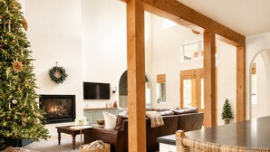 A modern living room with a fireplace, a Christmas tree, and a cozy seating area. - Luxury Golf Suncadia Retreat- Hot Tub + Sleeps 20 (Cle Elum)
