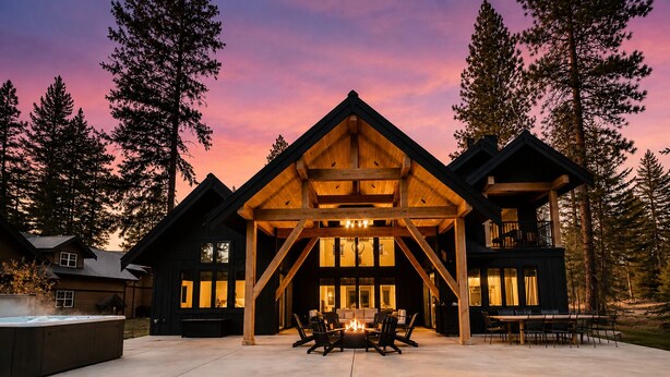 A large wooden cabin with a covered patio, multiple windows, and a fire pit. - Luxury Golf Suncadia Retreat- Hot Tub + Sleeps 20 (Cle Elum)