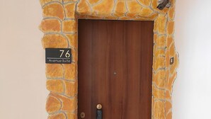 A door with a stone facade and a sign indicating "76 Avenue Suite". - 76 Avenue Suite - Very close to the city center (Reggio Calabria)