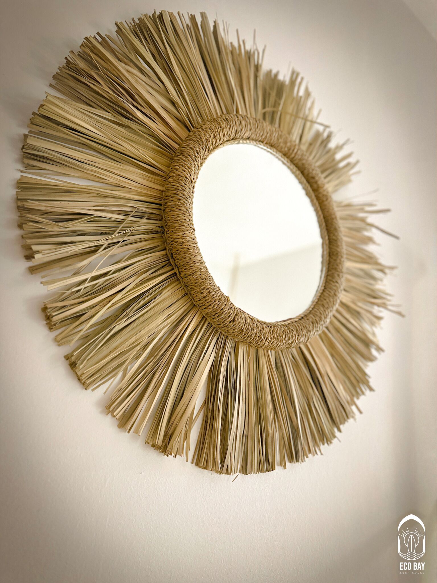 A round mirror with a woven frame.