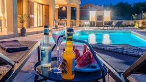 A poolside setting with lounge chairs, a table with drinks, and a pool in the background. - Lovely home in Jovici (Jovici)