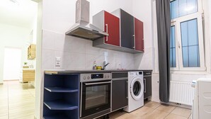 A compact kitchen with a built-in oven, a washing machine, and a microwave. - Lovely Room @2nd Vienna, Only 10-Min to Augarten (Vienna)