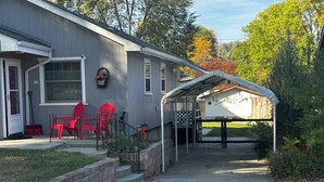 A residential house with a covered porch, a front door, and a small front yard with a lawn and a few plants. - Pet Friendly 2BR Home w/ fenced backyard (Billings)