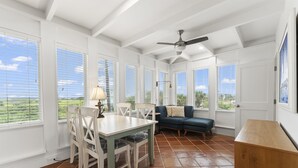 A bright, well-lit room with a dining table and chairs, a sofa, and a ceiling fan. - Oceanfront Oasis w BBQ Pet Friendly Beach Access (Saint Augusitne)