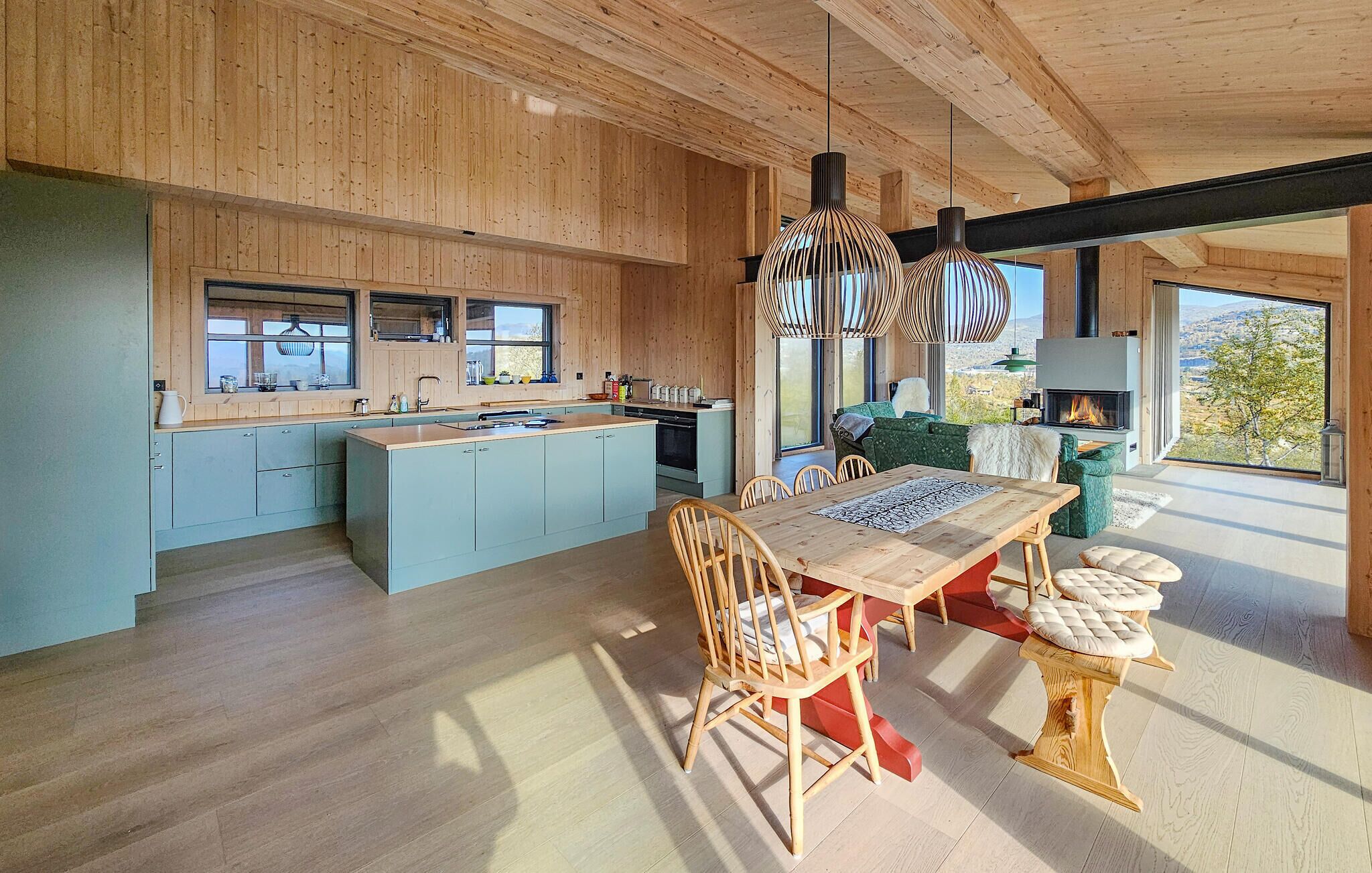 Een moderne keuken met houten kastjes, een centraal eiland en een eethoek met een houten tafel en stoelen.