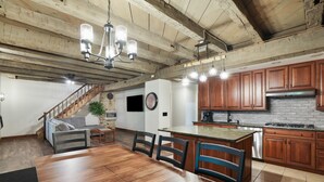 A spacious kitchen with wooden cabinets, a large island, and a dining area with a wooden table and chairs.