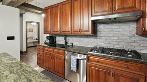 A kitchen with wooden cabinets, a stainless steel dishwasher, and a gas stove.