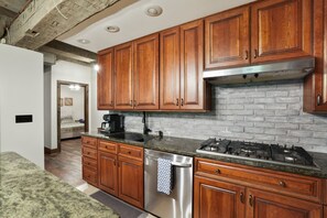 A kitchen with wooden cabinets, a stainless steel dishwasher, and a gas stove.
