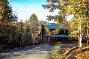 A lodge with a prominent wooden structure, a covered porch, and a driveway leading to the entrance.