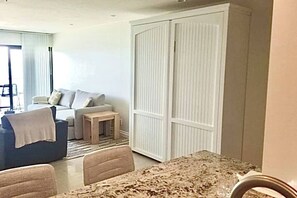 Un salon avec un canapé, une petite table et une armoire.