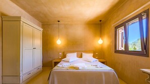 A bedroom with a bed, two bedside tables, a wardrobe, and a window with curtains. - Relax at Villa Rhea, just a short walk from the beautiful Ai Helis Beach (Svoronata)