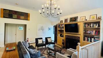 Smart TV, caminetto, libri, impianto stereo