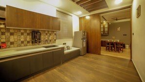 Una cucina moderna con mobili in legno, forno a incasso e frigorifero.