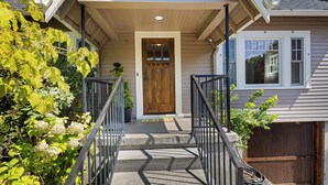 A house with a front porch, a wooden door, and a garage.