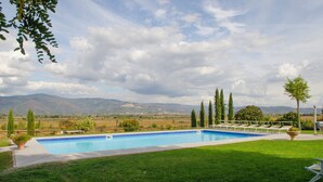 A rectangular swimming pool with a clear blue water, surrounded by a grassy lawn and a few trees. - AgriDepandance Deluxe Cortona Tuscany (Cortona)