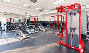 A gym with various exercise equipment, including weight machines and dumbbells.