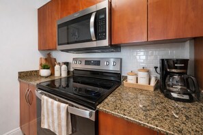 A kitchen with a microwave, stove, oven, and coffee maker.