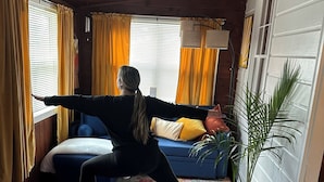 A room with a yoga mat, a bed, a sofa, and a potted plant. - Charming cottage with lake access, wood burning fire place, and WiFi (Elizaville)