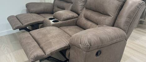 A reclining sofa with a built-in cup holder and storage compartments.