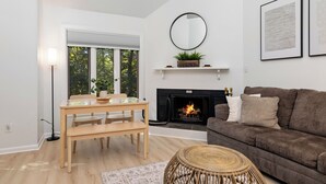 Una sala moderna con chimenea, una mesa de comedor y un sofá.