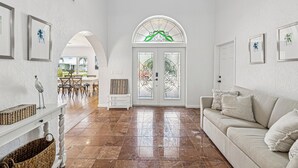 A spacious living area with a large window, a sofa, and a dining table.