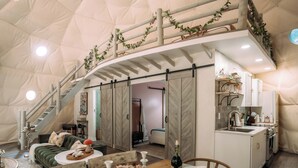 A spacious tent with a dining area, kitchen, and a staircase. - Magical Dome Perfect for Families & Groups-Hot Tub-Kid Friendly-Firepit -Private (Nelsonville)