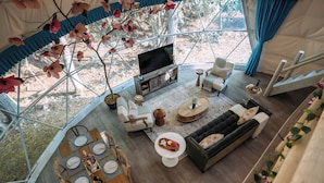 A spacious tent with a dining area, sofa, and TV. - Magical Dome Perfect for Families & Groups-Hot Tub-Kid Friendly-Firepit -Private (Nelsonville)