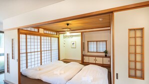 Ein traditioneller japanischer Raum mit Tatami-Böden, Schiebetüren und Deckenventilator.