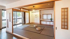 Ein traditioneller japanischer Raum mit Tatami-Böden, Schiebetüren und einem Shoji-Bildschirm.