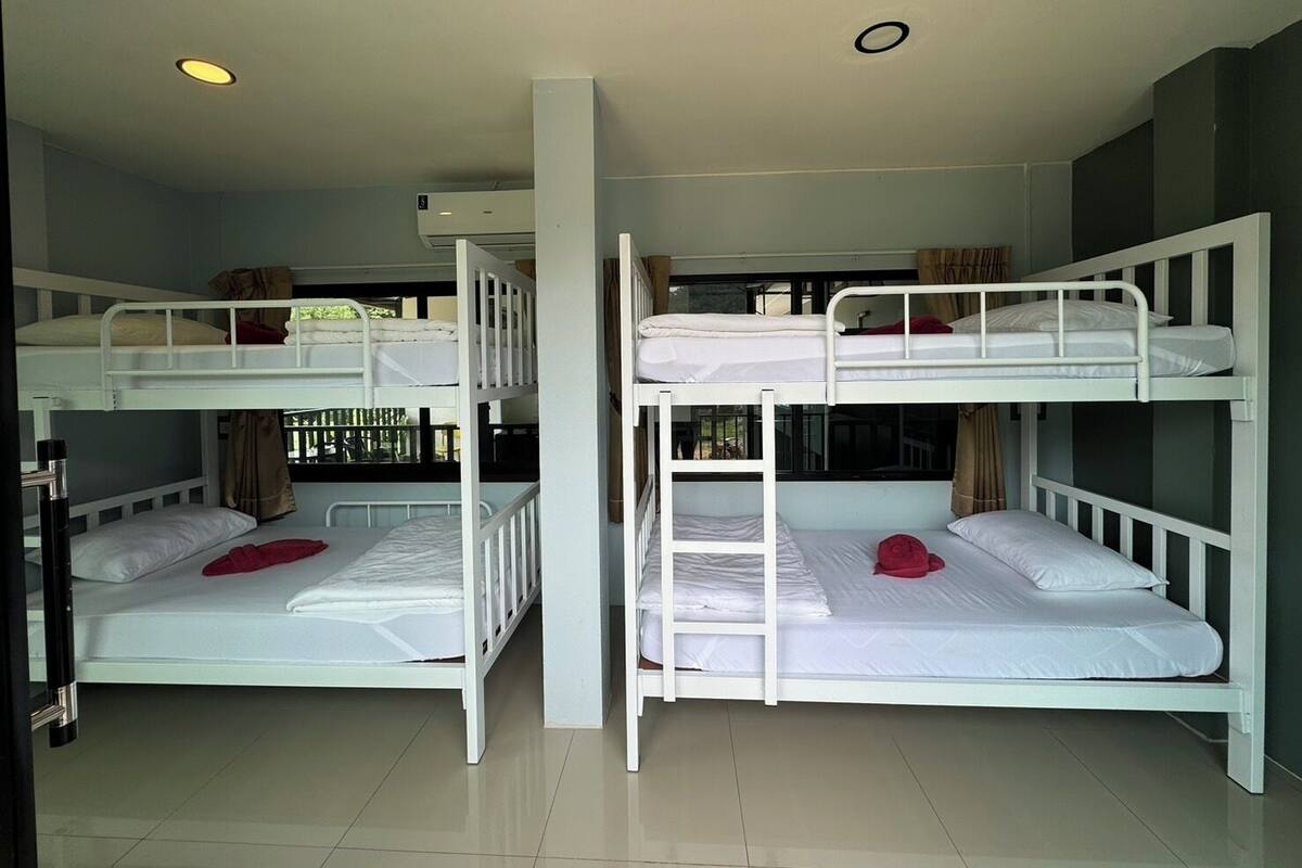 A room with bunk beds, a window, and a ceiling light.