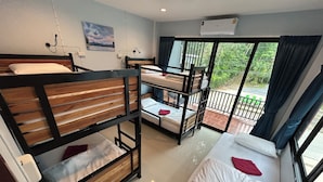 A dormitory room with bunk beds, a balcony with a view, and an air conditioning unit. - Boom Hostel Khao Sok (Phanom)