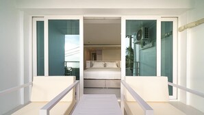 Ein modernes Hotelzimmer mit Balkon, Bett und Meerblick.