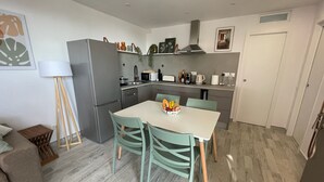 A compact kitchen with a dining table, chairs, and a fruit bowl. - Apartamerica Garden Apartment, 150 Metres From The (Playa de Las Americas)