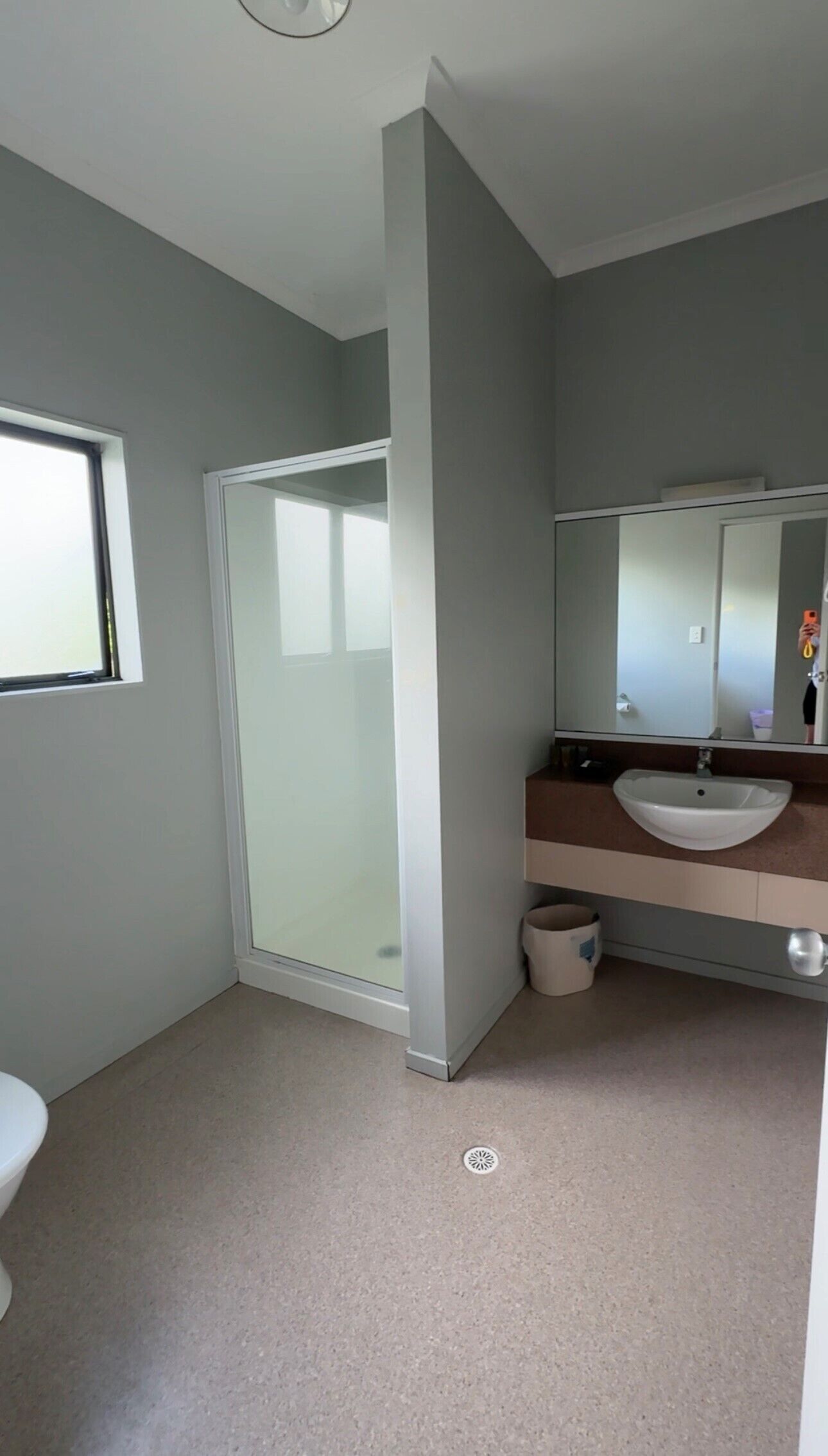 Une salle de bain moderne avec une douche à parois de verre, un lavabo avec un miroir et des toilettes.