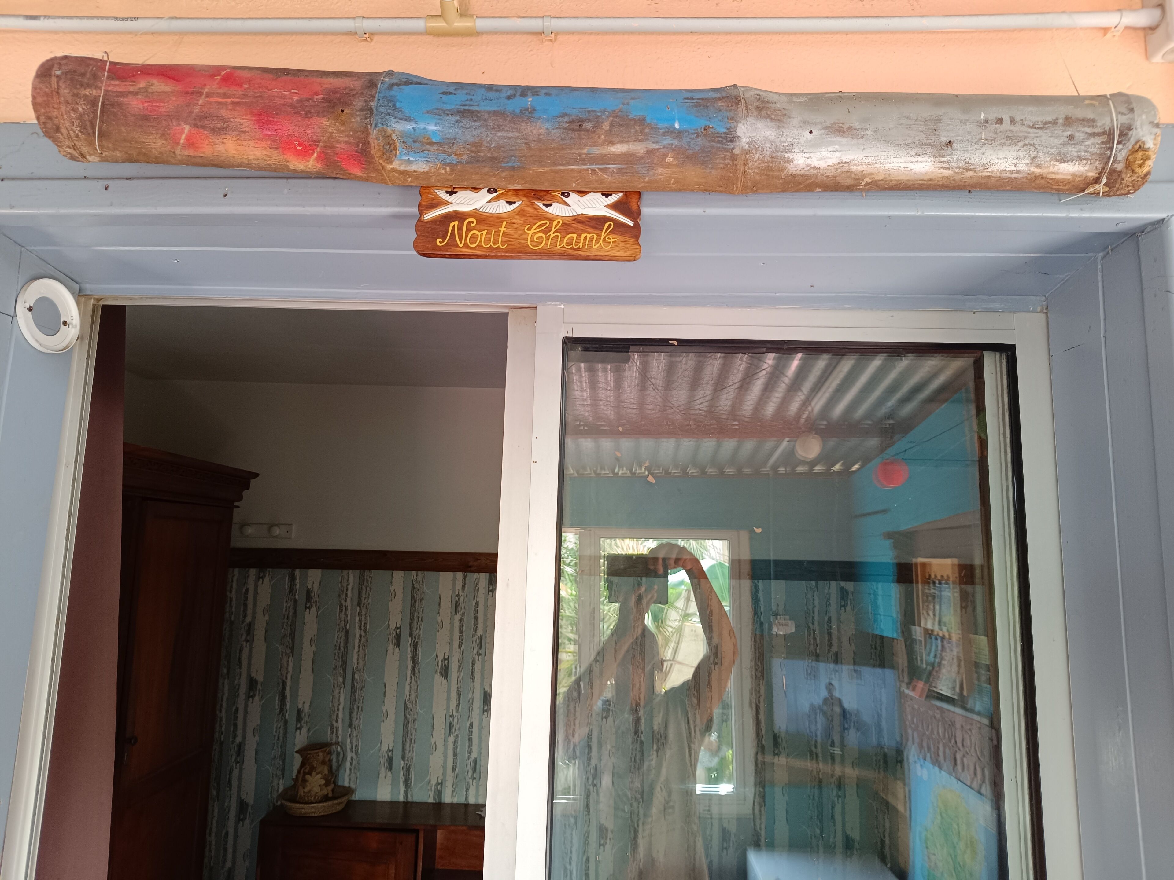 A wooden sign with the text "Nout Chanbo" above a door.