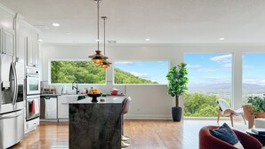 Una cocina moderna con una isla de mármol, electrodomésticos de acero inoxidable y vistas a las montañas.