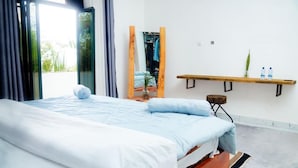 A bedroom with a bed, a mirror, a shelf with bottles, and a view of the outdoors. - Esspasso  (Musanze)