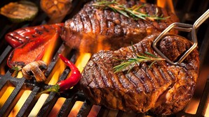A steak being grilled on a barbecue with vegetables and a red chili pepper. - Esspasso  (Musanze)