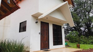 Una casa moderna con fachada blanca, una puerta de madera y techo de tejas.