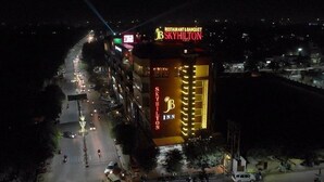 A multi-story building with signage for 'SkyHilton' and 'SkyHilton Inn' at night. - JB SKY HILTON INN (Lucknow)