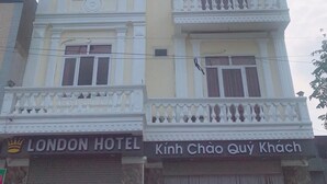 Un edificio con un letrero que dice 'LONDON HOTEL' y 'Kính Chào Quý Khách'.