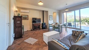 Una zona d'estar àmplia amb sofà, televisió i taula de menjador.