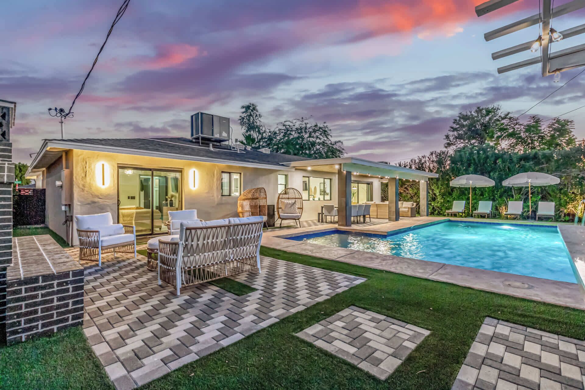 A modern house with a swimming pool, outdoor seating, and a well-maintained garden.