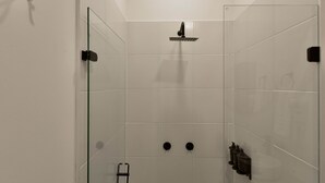 A modern shower area with a glass enclosure, a handheld showerhead, and a wall-mounted control panel. - w* | Brilliant Loft near Parque 93 (Bogotá)