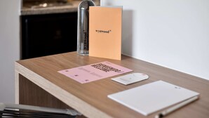 A wooden desk with a bottle, a card, and a notebook. - w* | Brilliant Loft near Parque 93 (Bogotá)