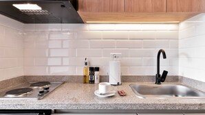 A modern kitchen with a stainless steel stove, a sink, and wooden cabinets. - w* | Brilliant Loft near Parque 93 (Bogotá)