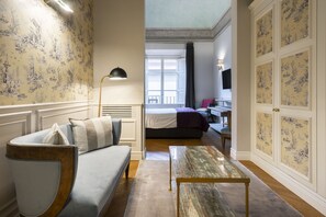 Une chambre d’hôtel avec un canapé, un lit, un bureau et une télévision.