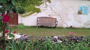 A stone wall with a wooden bench, a sign indicating 'Le Pardes Chambres d'hotes', and a garden with various plants and flowers. - Apartment with garden and pool near fabulous sights (Rocamadour)